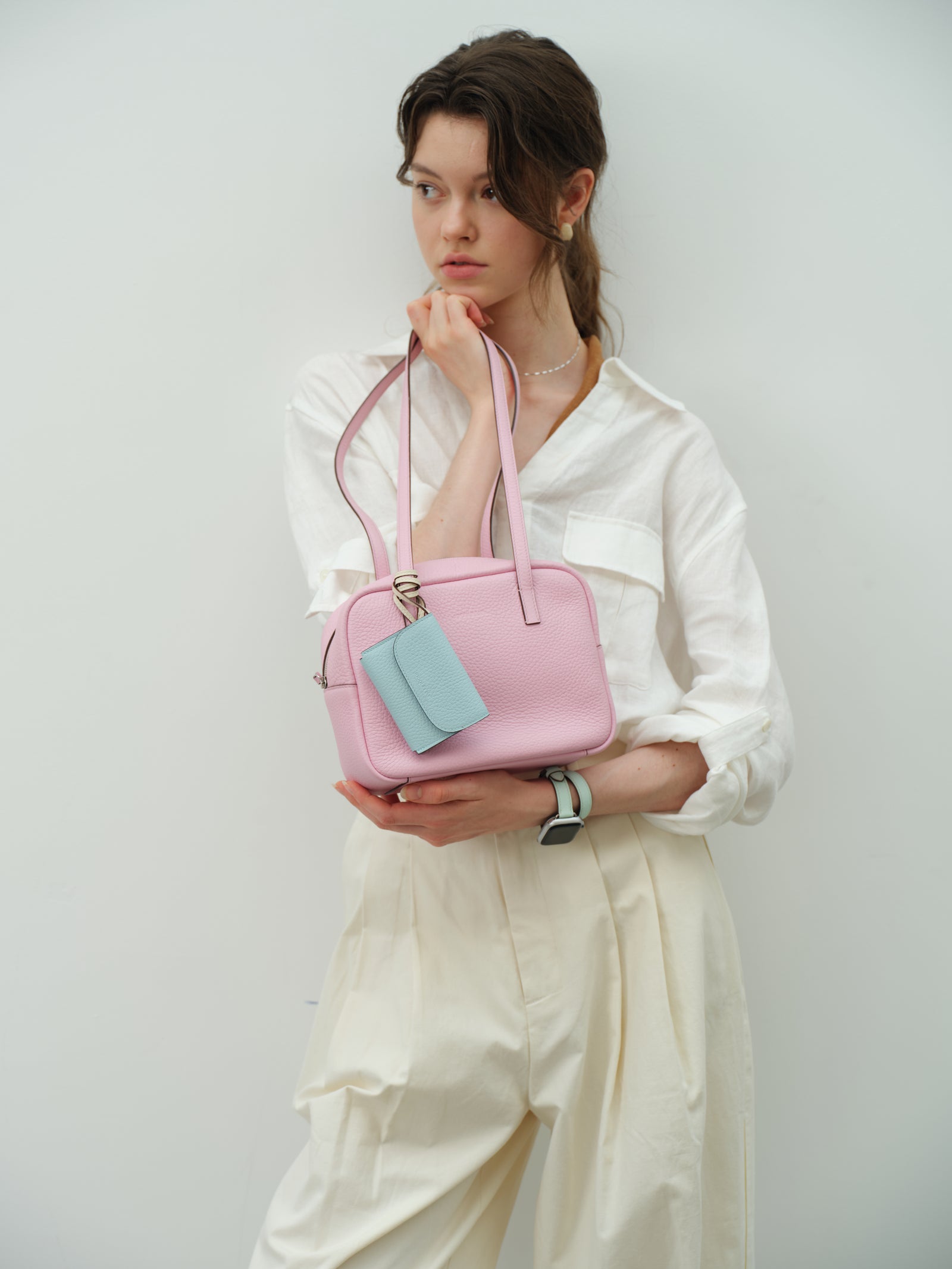 Pink leather bag with a pale blue card holder