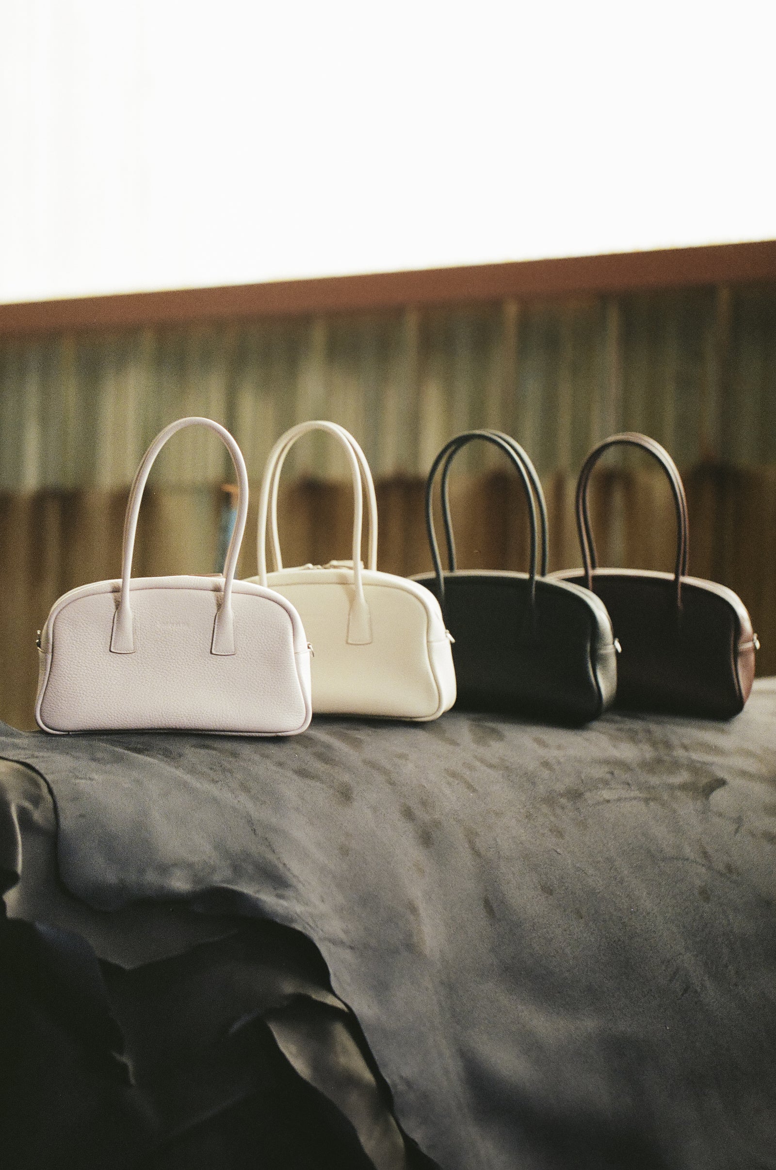 Four LUMA bags lined up on a leather hide