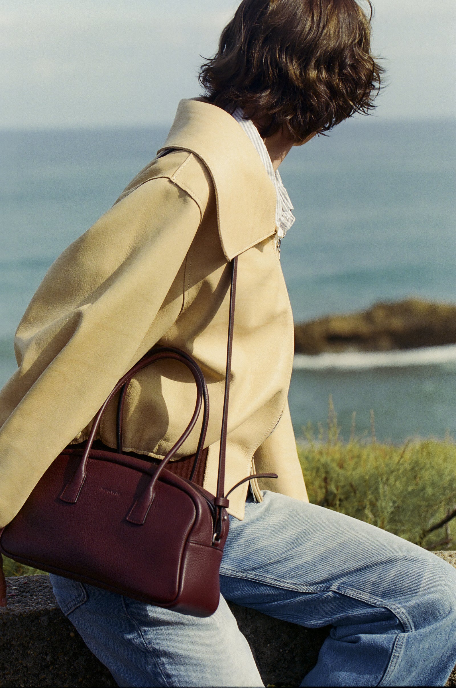 LUMA in Black Cherry worn crossbody by the sea