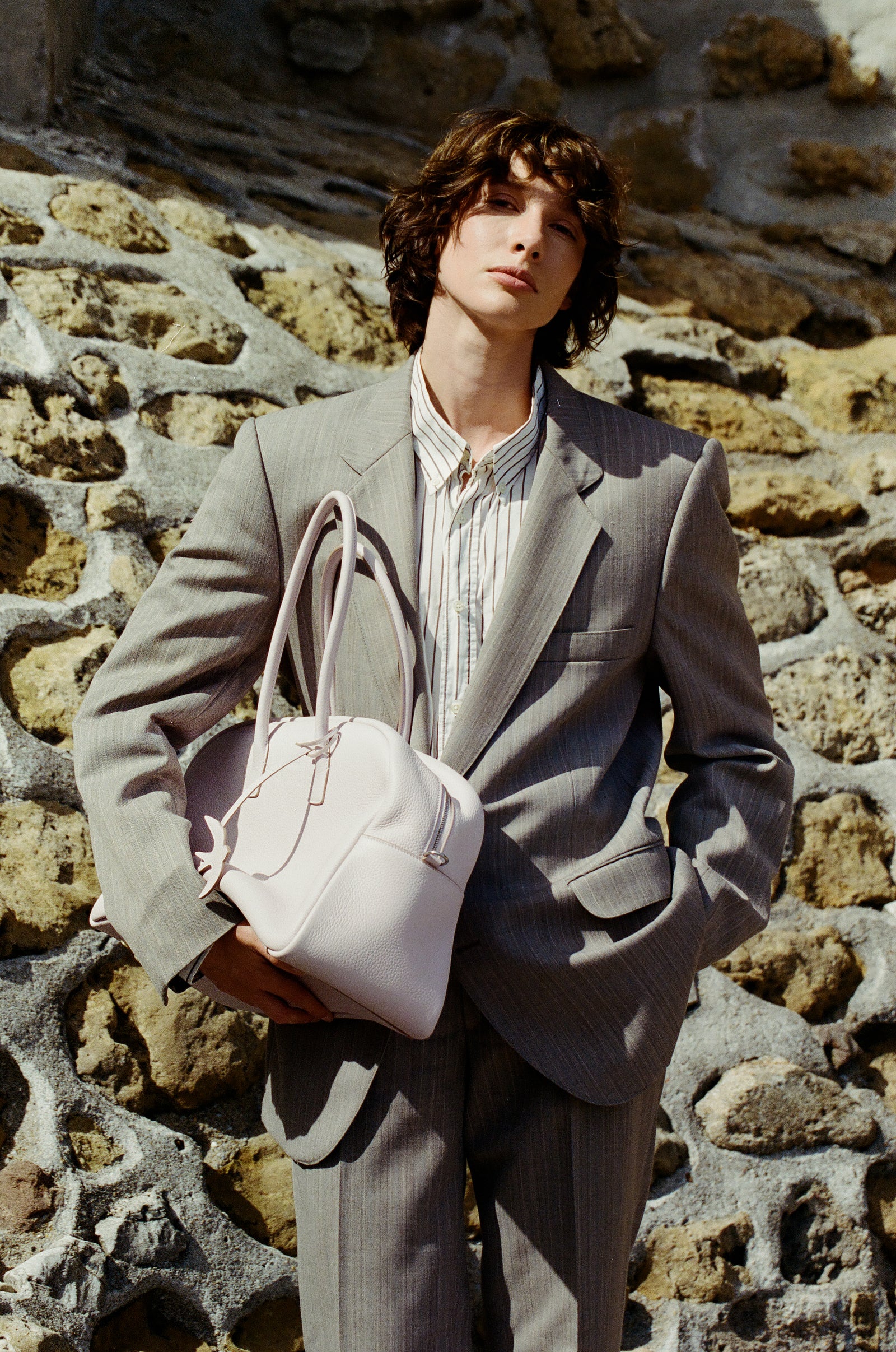 LUMA in Bouton de Rose against a stone wall